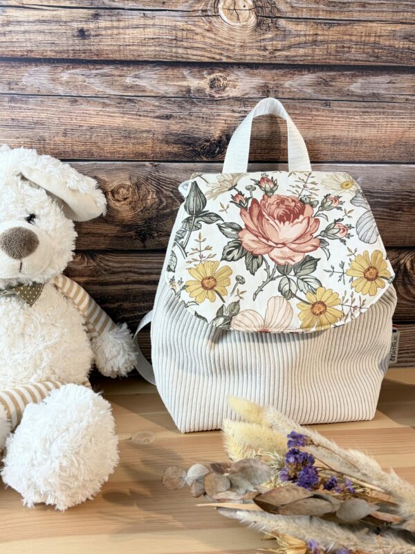 Sac a dos enfant pour la crèche ou la maternelle. grosse fleur sur le rabat et velours côtelé beige sur le corps.