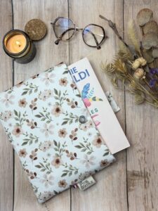 pochette à livre broché dans un tissu fleuri pastel avec une fermeture aimantée.