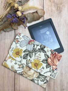 Pochette pour liseuse fait main dans un tissu coton oeko tex, avec des motifs à grosses fleur. Elle possède une poche intérieur pour ranger son câble.