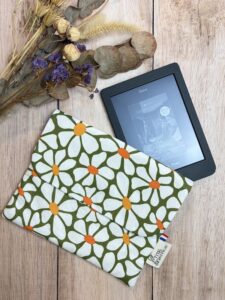 Pochette pour liseuse fait main dans un tissu coton oeko tex, avec des motifs à fleur blanche type marguerite sur un fond vert. Elle possède une poche intérieur pour ranger son câble.