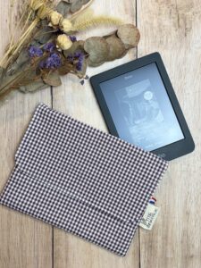 Pochette pour liseuse fait main dans un tissu coton vichy de couleur prune oeko tex. Elle possède une poche intérieur pour ranger son câble.