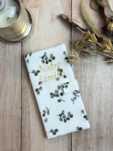 Protège livret de famille fait main en double gaze eucalyptus et avec une broderie "Notre famille", avec une fermeture aimantée