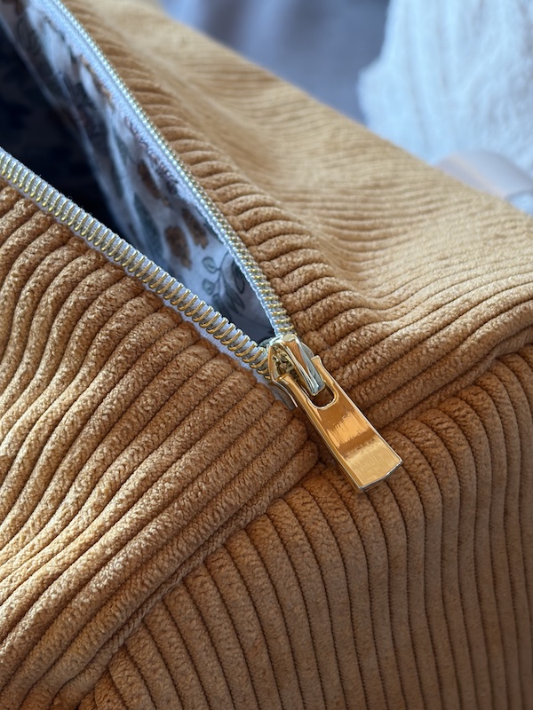 Détail de la fermeture du sac de voyage fait main en velours côtelé ocre.